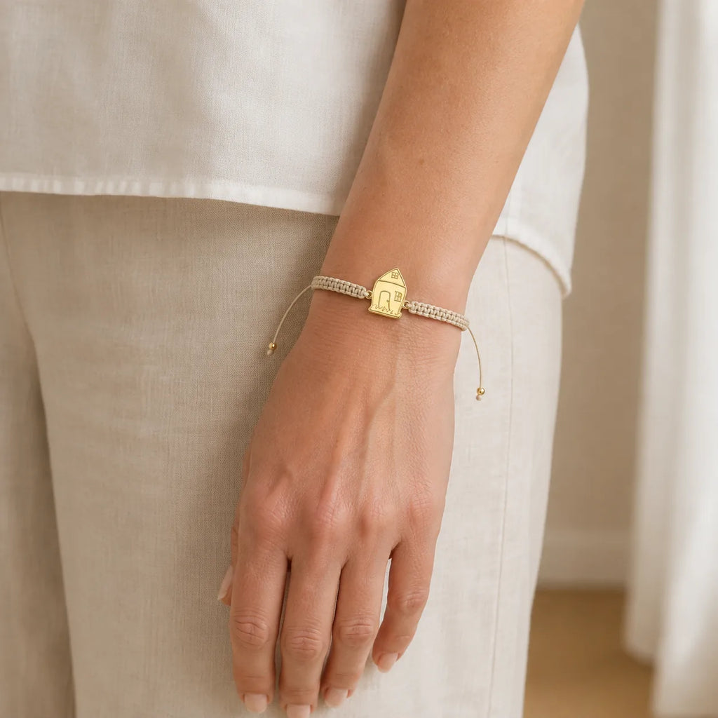 DRAWELL custom house gold cord bracelet worn on wrist