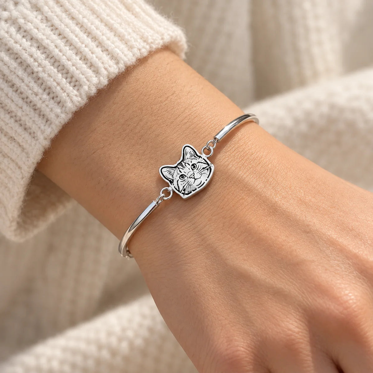 Personalized silver pet portrait bangle worn in natural light
