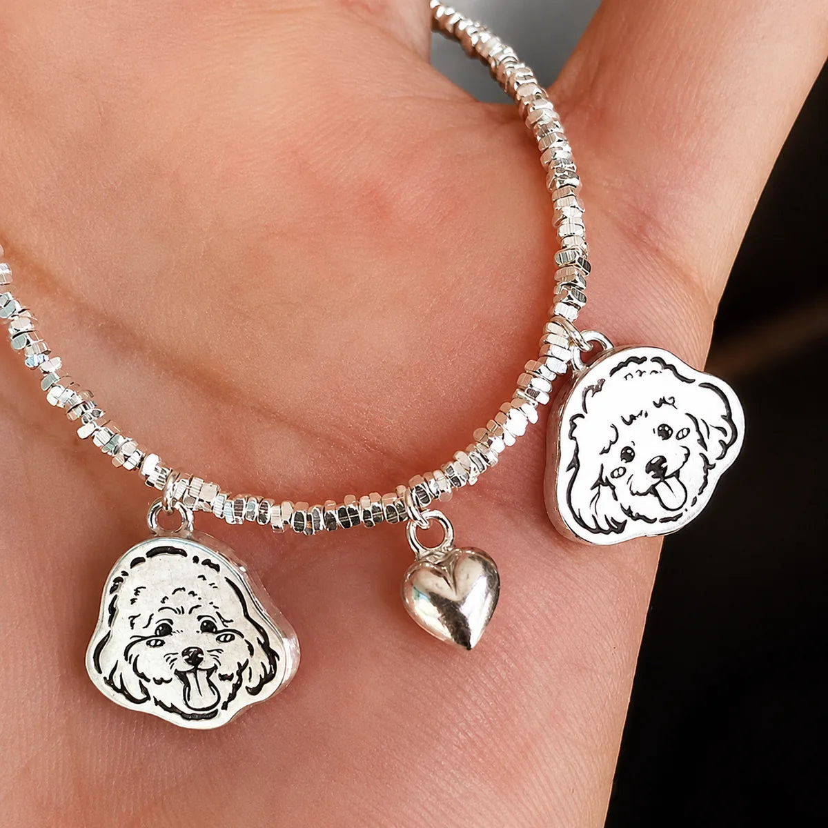 Two-pet silver bracelet option with two custom portrait charms and a heart charm